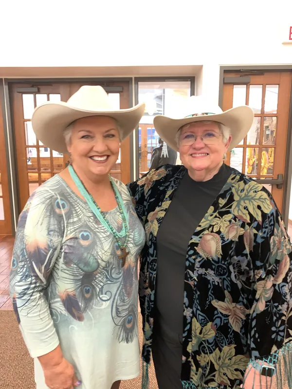 Judy James with a friend, both in cowboy hats