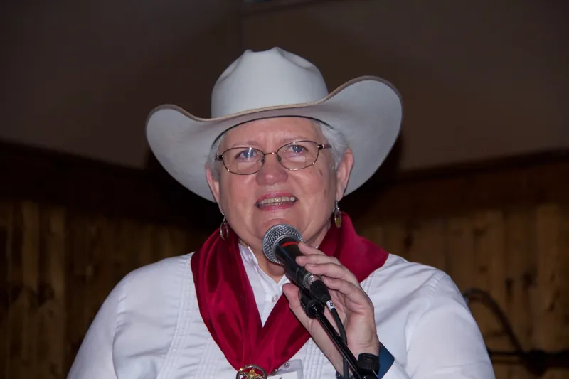 Judy James singing into a handheld microphone