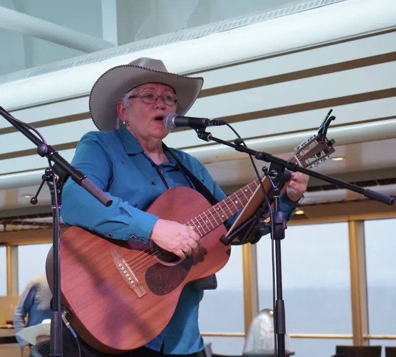Judy James singing with her guitar