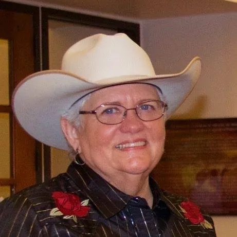 Portrait of Judy James in a white cowboy hat and embroidered Western shirt