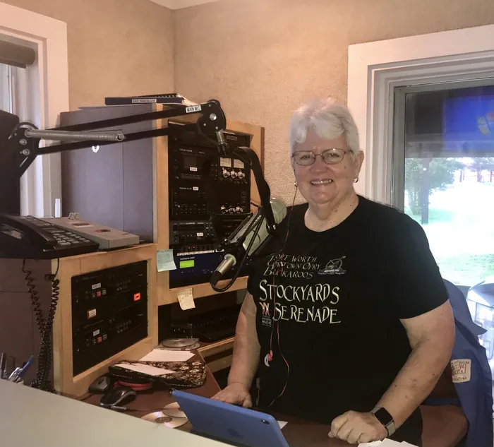 Judy James smiling at the microphone in the radio studio